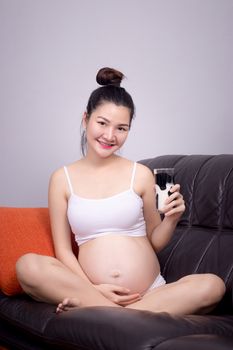 Pregnant healthy concept. A portrait of a Beautiful asian pregnant woman drink milk from glass in hand. Beautiful Asia model female in her 20s