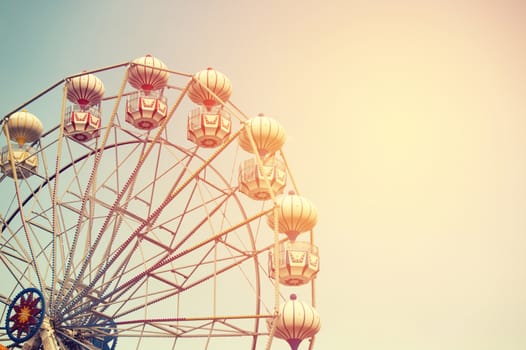 Ferris wheel on sky background with sunlight retro effect image