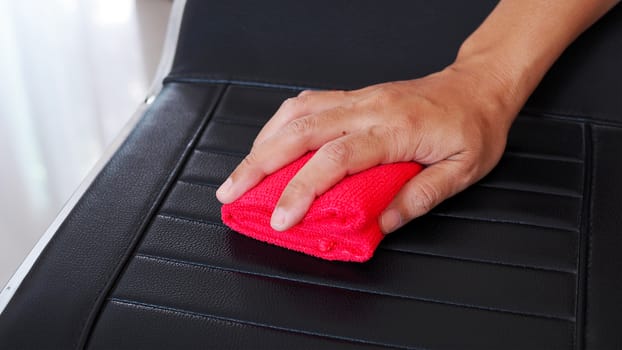 Using red cloth to wipe on chair to clean and prevent germs in house.