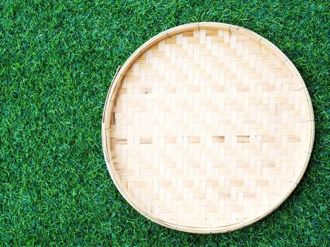 Above of bamboo weave basket on green grass, background for design with copy space for text.