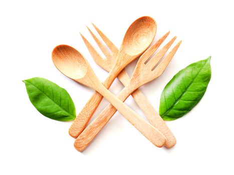 Wooden spoon and fork and green leaf, Natural wooden utensils Eco-friendly And safe for health Isolated on white background