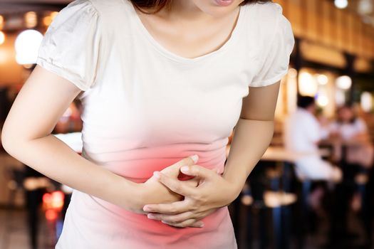 Woman suffer from stomachache or Gastroenterologist. Concept with Healthcare And Medicine. Pain in red color. Isolate with clipping path on blur restaurant background