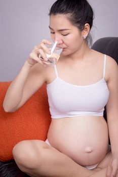 Pregnant healthy concept. A portrait of a Beautiful asian pregnant woman drink pure water from glass in hand. Beautiful Asia model female in her 20s