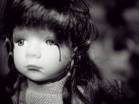 Anti children violence family problem campaign concept : cute girl child doll crying with blood of tear from family social violence. black and white color