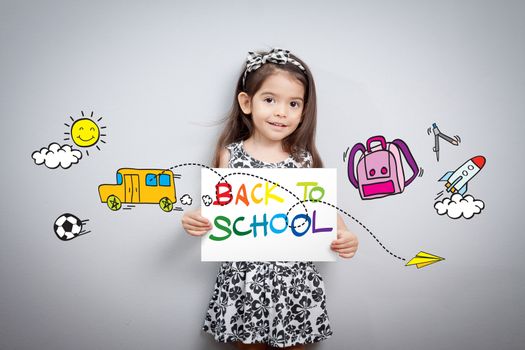 Back to school concept: Cheerful smiling little girl hold paper write back to school with colorful with cartoon around. Cute mixed race girl half Thai, half English model 3 years old.