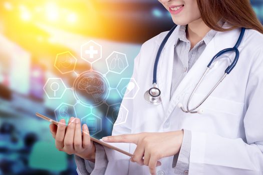 Healthy technology concept : Young Asian woman doctor using technology on tablet for patient chart with hologram graphic chart popup from tablet on doctor hand for patient consultants,  anonymous face