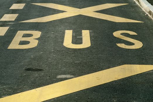 bus sign with yellow paint on asphalt