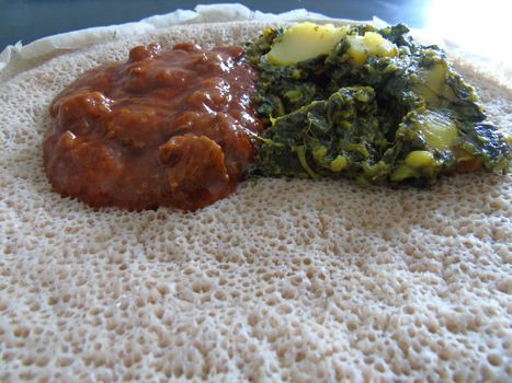 Asmara, Eritrea - 08/05/2020: Ethiopian and Eritrean food, assortment of main dishes. Injera is a sourdough flatbread made from teff flour. It is the national dish of Ethiopia, Eritrea.