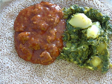 Asmara, Eritrea - 08/05/2020: Ethiopian and Eritrean food, assortment of main dishes. Injera is a sourdough flatbread made from teff flour. It is the national dish of Ethiopia, Eritrea.