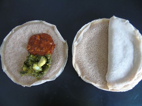 Asmara, Eritrea - 08/05/2020: Ethiopian and Eritrean food, assortment of main dishes. Injera is a sourdough flatbread made from teff flour. It is the national dish of Ethiopia, Eritrea.