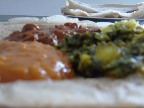 Asmara, Eritrea - 08/05/2020: Ethiopian and Eritrean food, assortment of main dishes. Injera is a sourdough flatbread made from teff flour. It is the national dish of Ethiopia, Eritrea.