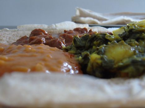 Asmara, Eritrea - 08/05/2020: Ethiopian and Eritrean food, assortment of main dishes. Injera is a sourdough flatbread made from teff flour. It is the national dish of Ethiopia, Eritrea.