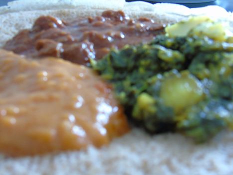 Asmara, Eritrea - 08/05/2020: Ethiopian and Eritrean food, assortment of main dishes. Injera is a sourdough flatbread made from teff flour. It is the national dish of Ethiopia, Eritrea.