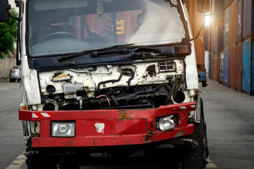 The truck is damaged and is parked in an industrial factory.