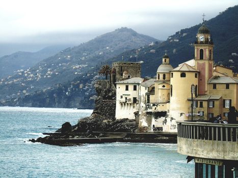 Liguria, Italy - 06/15/2020: Travelling around the ligurian seaside. Panoramic view to the seaside and the old villages. An amazing caption of the medieval coloured houses with grey sky in the background.