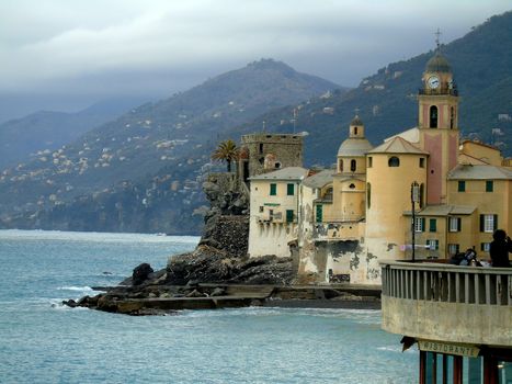 Liguria, Italy - 06/15/2020: Travelling around the ligurian seaside. Panoramic view to the seaside and the old villages. An amazing caption of the medieval coloured houses with grey sky in the background.