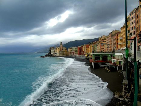 Liguria, Italy - 06/15/2020: Travelling around the ligurian seaside. Panoramic view to the seaside and the old villages. An amazing caption of the medieval coloured houses with grey sky in the background.