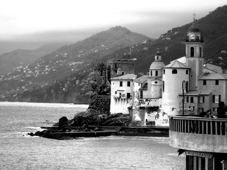 Liguria, Italy - 06/15/2020: Travelling around the ligurian seaside. Panoramic view to the seaside and the old villages. An amazing caption of the medieval coloured houses with grey sky in the background.