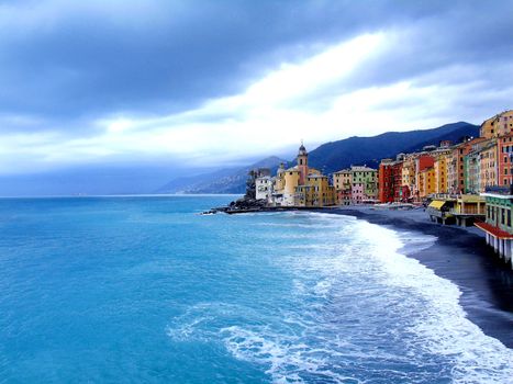 Liguria, Italy - 06/15/2020: Travelling around the ligurian seaside. Panoramic view to the seaside and the old villages. An amazing caption of the medieval coloured houses with grey sky in the background.