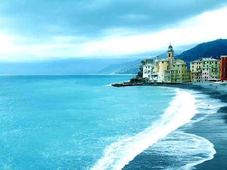 Liguria, Italy - 06/15/2020: Travelling around the ligurian seaside. Panoramic view to the seaside and the old villages. An amazing caption of the medieval coloured houses with grey sky in the background.