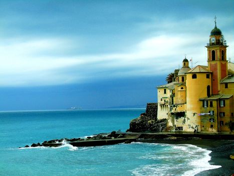 Liguria, Italy - 06/15/2020: Travelling around the ligurian seaside. Panoramic view to the seaside and the old villages. An amazing caption of the medieval coloured houses with grey sky in the background.