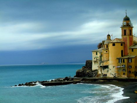 Liguria, Italy - 06/15/2020: Travelling around the ligurian seaside. Panoramic view to the seaside and the old villages. An amazing caption of the medieval coloured houses with grey sky in the background.