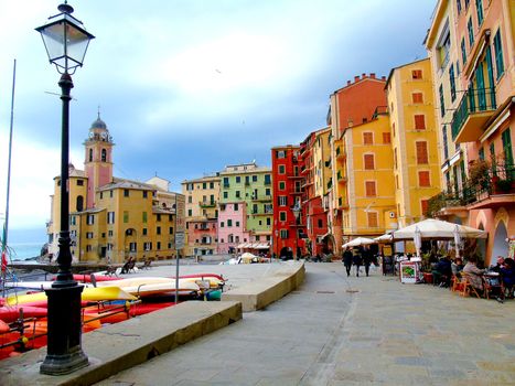 Liguria, Italy - 06/15/2020: Travelling around the ligurian seaside. Panoramic view to the seaside and the old villages. An amazing caption of the medieval coloured houses with grey sky in the background.