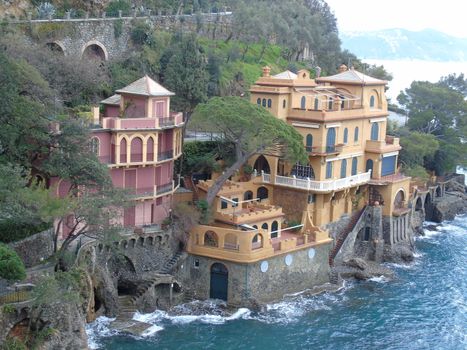 Liguria, Italy - 06/15/2020: Travelling around the ligurian seaside. Panoramic view to the seaside and the old villages. An amazing caption of the medieval coloured houses with grey sky in the background.