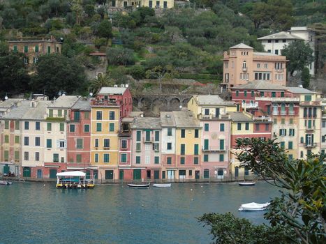 Liguria, Italy - 06/15/2020: Travelling around the ligurian seaside. Panoramic view to the seaside and the old villages. An amazing caption of the medieval coloured houses with grey sky in the background.
