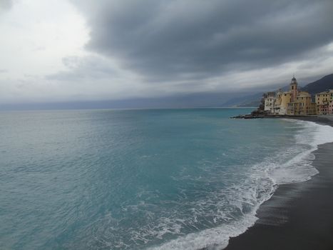 Liguria, Italy - 06/15/2020: Travelling around the ligurian seaside. Panoramic view to the seaside and the old villages. An amazing caption of the medieval coloured houses with grey sky in the background.