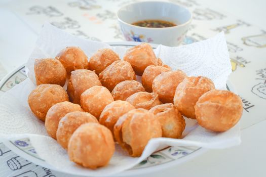 Closed up shot of Thai Appetizer Batter Fried Fish Balls and Dipping Sauce.