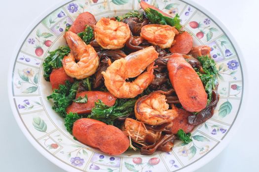 Stir fried Flat Noodle with black soy sauce, shrimps, Kale and Sausages. Thai food from chinese culture.