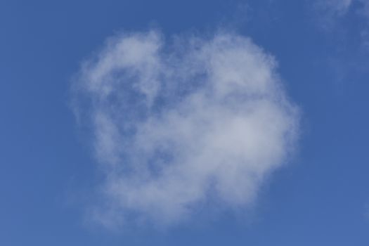 Background of a one single cumulus cloud with a blue clear sky