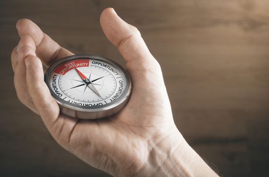 Man hand showing compass with needle pointing the text best opportunity. Concept image to illustrate business or career opportunities.
