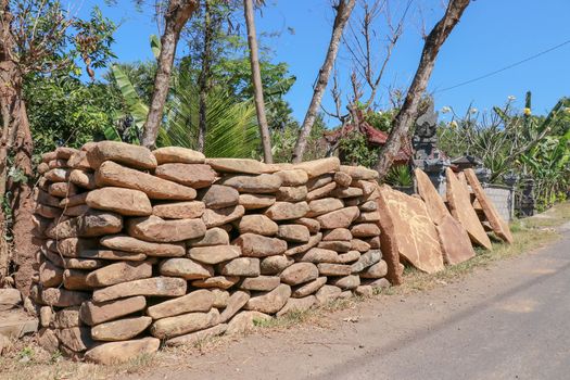 Big flat stones of yellow color for pathway. Natural building material. Boulders stacked on top of each other and ready for sale. Huge heavy stones.