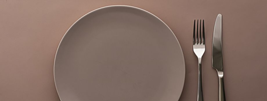 Empty plate and cutlery as mockup set on brown background, top tableware for chef table decor and menu branding design