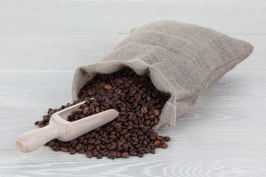 Coffee bean scoop and bag on wood surface