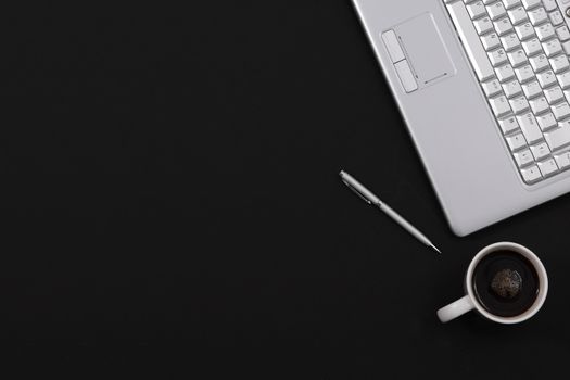 A black minimalist home office desk pen coffee laptop top view with copy space