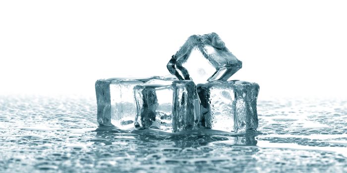 A group of ice cubes melting blue and black background