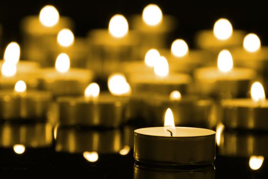 Candles on christmas night signifying hope. Gold. Background.With selective focus.