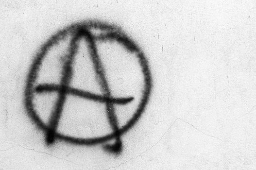 Symbol of Anarchy painted on a gray concrete wall. Ideal for concepts and backgrounds. Space for text.