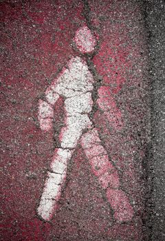 White pedestrian signal of person on asphalt, walkway pedestrian. Information and security. Faded red pedestrian stripes.