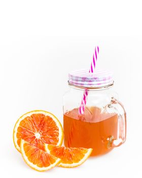 Mason jar glass of tea with oranges isolated on a white background. Space for text.