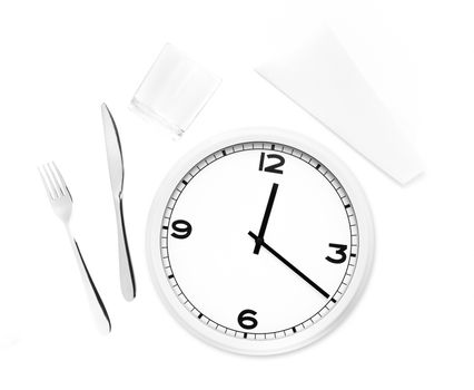 Fork, knife, glass, napkin and white round clock isolated in white background. Time to eat concept.