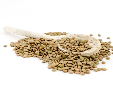 Heap of green lentil with wooden spoon isolated on white background with wooden spoon. Shallow DOF.