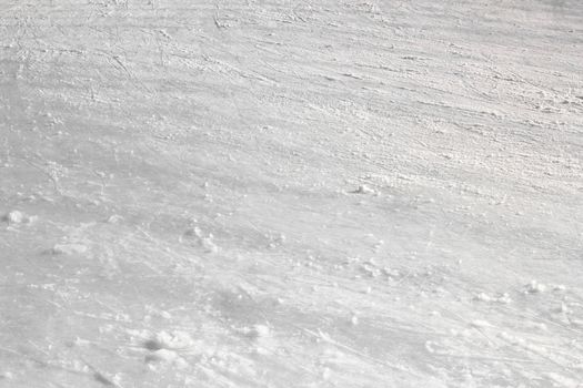 Close up of white ice surface with a traces left by the skates. Ideal for texture and backgrounds.