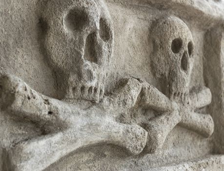 Ancient stone skull with crossbones. Old sculpture. Ideal for concepts and backgrounds.