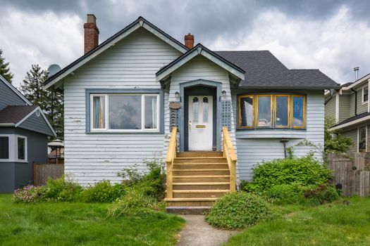 Old residential house with neglected lawn on the front yard