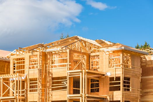 Wood frame apartment building under construction on sunny day on blue sky background