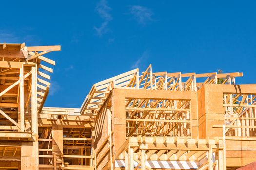 Wood frame apartment building under construction on sunny day on blue sky background